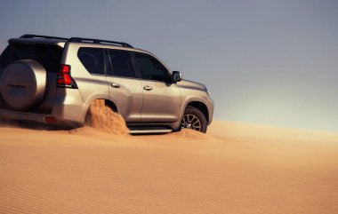 Namib Çölü 'nün uzak kumda sıkışmış bir SUV, Namibya' daki zorlu sürüş koşullarının ve çöl keşiflerinin gerçekliğini vurgulayan editoryal yakalama. 