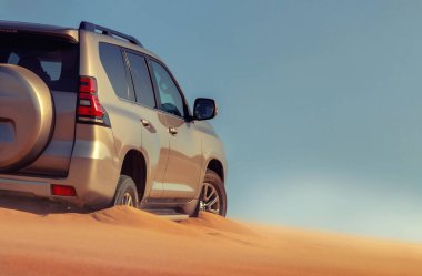 Namib Çölü 'nün uzak kumda sıkışmış bir SUV, Namibya' daki zorlu sürüş koşullarının ve çöl keşiflerinin gerçekliğini vurgulayan editoryal yakalama. 