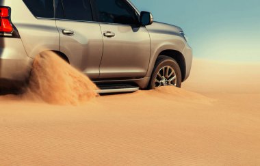 Namib Çölü 'nün uzak kumda sıkışmış bir SUV, Namibya' daki zorlu sürüş koşullarının ve çöl keşiflerinin gerçekliğini vurgulayan editoryal yakalama. 