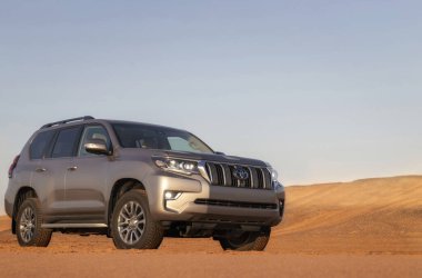 Toyota Land Cruiser Namibias Çölü 'nün derin kırmızı kumlarında dayanıklılık ve off-road gücü sergiliyor. Seyahat, macera ve zorlu keşif temaları için idealdir.. 
