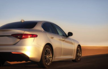 Namibya 'da boş bir çöl yolunda giden gümüş bir arabanın arka görüntüsü, özgürlüğü, yalnızlığı ve Afrika' daki keşiflerin ruhunu simgeliyor.. 