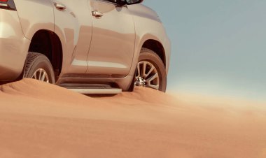 Yumuşak kum tepeciklerinde kapana kısılmış SUV engebeli koşulları ve gerçek off-road zorluklarını ön plana çıkarıyor. Açık hava, çöl ve hayatta kalma fotoğrafçılığı için ideal..