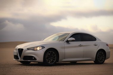 Alfa Romeo Giulia engin çöl arazisinde yandan fotoğraflandı. Editör ve otomotiv projeleri için İtalyan tasarımı ve off-road atmosferinin çarpıcı bir karışımı. 