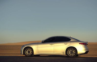 Alfa Romeo Giulia engin çöl arazisinde yandan fotoğraflandı. Editör ve otomotiv projeleri için İtalyan tasarımı ve off-road atmosferinin çarpıcı bir karışımı. 