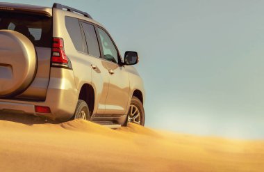 Namib Çölü 'nün uzak kumda sıkışmış bir SUV, Namibya' daki zorlu sürüş koşullarının ve çöl keşiflerinin gerçekliğini vurgulayan editoryal yakalama. 