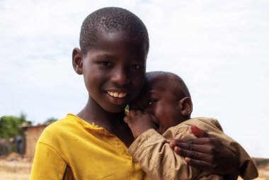 Namibya 'daki bir mülteci kampından duygusal bir sahne: Genç bir Afrikalı çocuk ağlayan erkek kardeşini teselli ediyor. Krizde aileyi, özeni ve hayatta kalmayı sembolize eden hareketli bir görüntü.