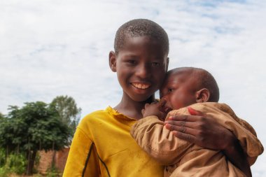 Namibya 'daki bir mülteci kampından duygusal bir sahne: Genç bir Afrikalı çocuk ağlayan erkek kardeşini teselli ediyor. Krizde aileyi, özeni ve hayatta kalmayı sembolize eden hareketli bir görüntü.