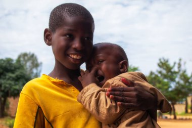 Namibya 'daki bir mülteci kampından duygusal bir sahne: Genç bir Afrikalı çocuk ağlayan erkek kardeşini teselli ediyor. Krizde aileyi, özeni ve hayatta kalmayı sembolize eden hareketli bir görüntü.