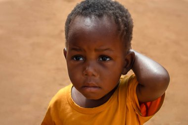 Namibya 'daki bir mülteci kampında yalnız başına kalan siyah bir çocuğun yüzü hüzün ve sessizlik ile işaretlenmişti. Zorlukları ve insan gücünü yansıtan güçlü ve duygusal bir editör imajı..