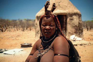 Namibya 'daki Himba kadınının özgün bir görüntüsü. Geleneksel boyası ve el yapımı aksesuarları var. Afrika 'nın zengin kabile kültürü ve kadınsı gücü hakkında gerçek bir içgörü..