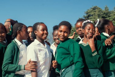 Mutlu Afrikalı çocukların okul kıyafetleriyle dışarıda vakit geçirmelerinin özgün bir görüntüsü. İçten, yürek ısıtan enerji, birlik ve gençlik iyimserliği dolu bir an.. 