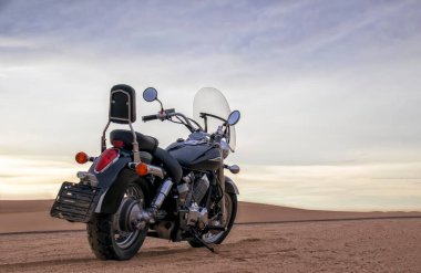 Fırtınalı bulutlar tarafından çerçevelenmiş, açık çölde tek başına park edilmiş bir arazi bisikleti. Yalnızlık, adrenalin ve iki tekerlek üzerinde zorlu bir keşif için mükemmel bir tema..