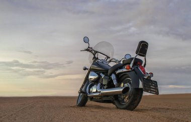 Fırtınalı bulutlar tarafından çerçevelenmiş, açık çölde tek başına park edilmiş bir arazi bisikleti. Yalnızlık, adrenalin ve iki tekerlek üzerinde zorlu bir keşif için mükemmel bir tema..