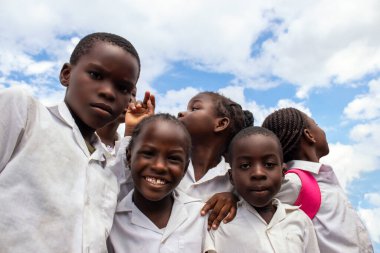 Üniformalı neşeli Afrikalı öğrenciler dışarıda keyifli bir anın tadını çıkarıyorlar. Doğal ışıkta yakalanan bu gerçek görüntü öğrenmeyi, dostluğu ve gençliğin coşkulu ruhunu yansıtıyor..