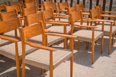 Bir etkinlikten önce sıra sıra dizilmiş boş ahşap vintage sandalyeler. Dışarıda bir sürü tahta koltuk var. Kamu etkinliği mobilya