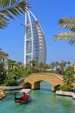 Ünlü Burj al Arap Oteli manzaralı Madinat Jumeirah kanallarında geleneksel Arap abra tekne gezisi. Popüler seyahat simgesi. Dubai, İHA. 2022