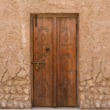 Ortadoğu geleneksel ahşap ön kapı, eski şehir bölgesinde oyulmuş oryantasyon tasarımı detaylarıyla yıpranmış. Tipik Arap dış biçimi.