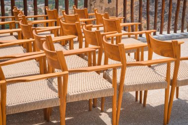 Bir etkinlikten önce sıra sıra dizilmiş boş ahşap vintage sandalyeler. Dışarıda bir sürü tahta koltuk var. Kamu etkinliği mobilya