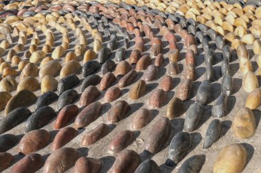 Ayak masajı için refleksoloji kaldırım taşlarının yolu. Dışbükey yuvarlak çakıl taşlarından mozaik desen. Arkaplan olarak kayalardan desenli yüzey