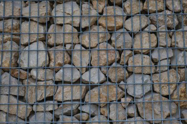 Havaya dayanıklı ve paslanmaz Gabion duvar, kaynaklı ağ ve kaya taşları bahçe çitleri. Stone Basket Kafesi arka planı. Kaya dolu tel iş kabı, istinat duvarı olarak kullanılıyor