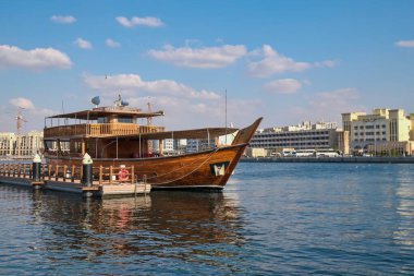 DUBAI, BAE - 5 Ocak 2025: Deira Creek limanında demirlemiş eski bir ahşap gemi Dhow turistik turistik gezisi için. Limanda yüzen restoran, geleneksel yemek turu..
