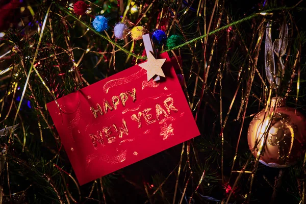 Cartolina con gli auguri di Buon Anno appesa sull'albero di Natale 