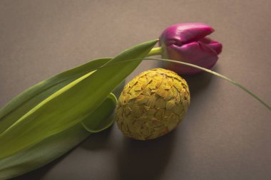 Composizione pasquale, uovo con il mosaico fatto dei gusci dipinti di colore gialli e con il fiore di tulipano 