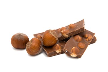 Pieces of milk chocolate with hazelnuts isolated on white background.