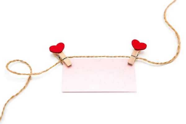 白い背景に孤立したロープの上に赤いハートと空白のグリーティングカードを持つ木製の装飾服ピン バレンタインデーのコンセプト スペースのコピー ストックフォト