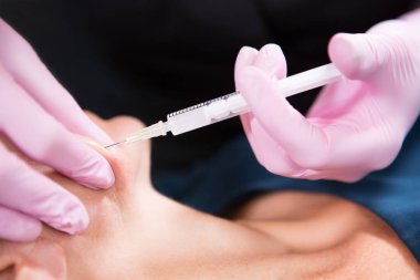 Beautician in a beauty salon makes injections with a syringe. Anti aging treatment. Skin care and rejuvenation treatments.
