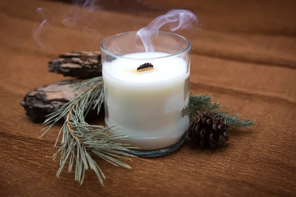 Extinct scented candle with smoke for relax with a coniferous composition.