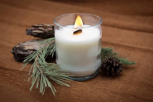 Burning scented candle for relax with a coniferous composition.