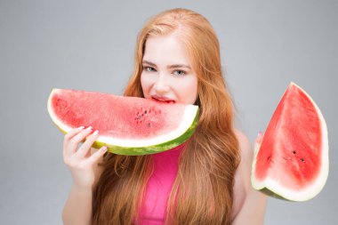 Happy young beautiful woman eating watermelon isolated on gray background. Healthy eating concept. Diet.