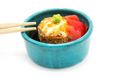 Beyaz arka planda zencefil, wasabi ve çubuklu soya soslu fırında suşi rulosu..