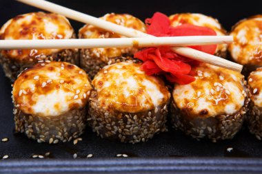 Soya soslu fırında suşi, zencefil ve çubuk. Paket yemek..