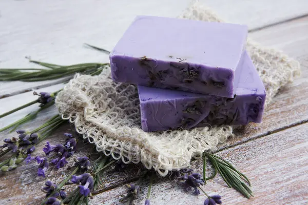Lavender soap with flowers on a vintage wooden board.