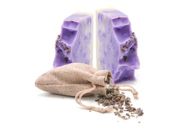 Beyaz zemin üzerinde kurumuş organik lavanta çiçekleri olan lavanta sabunu ve bez torbası. Organik vücut bakım ürünleri. El yapımı..