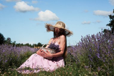 Genç, seksi, güzel bir kadın. Çiçeklerle dolu bir sepet gökyüzünde otururken rahatlıyor..