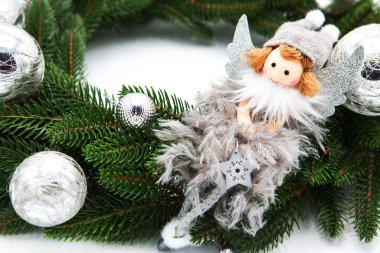 Gümüş Noel meleği bebeğiyle süslenmiş Firavun çelengi ve beyaz arka planda izole edilmiş parlak toplar. Yeni yıl. Boşluğu kopyala.