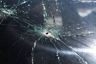 Camdaki kurşun deliği, gerçek bir kurşun deliği. Kırık araba ön camı ve çatlakları..