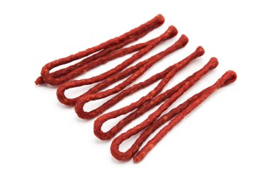 Beyaz arka planda izole edilmiş kurutulmuş mini füme sosis yığını. Et ürünleri ve lezzetler. Üst görünüm.