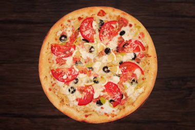 Pizza with seafood. Appetizing freshly baked pizza isolated on a wooden background. Pizza with a filling of red fish, tomatoes, cheese, olives, lemon, cream sauce and onions. clipart