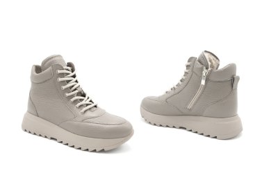 Beyaz arka planda kürk astarlı şık deri bağcıklı botlar. Her yönden bak. İzole edilmiş spor ayakkabılar.