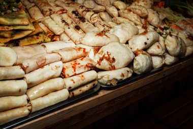 Tezgahın üzerinde meyveli börek ve krep var. Geleneksel Ukrayna mutfağı. Maslyannita tatili. Bir sokak fuarında yiyecek satmak. Gidecek sokak yemeği. Fast food.