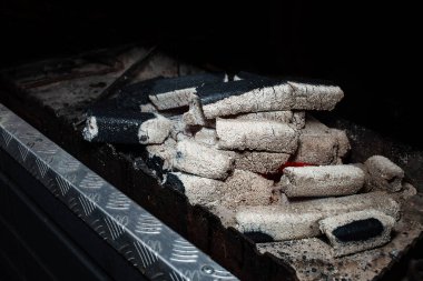 Kamp ateşinde yanan mangal kömürü kömürleri siyah arka planda izole edilmiş. Organik yakıt. Turizm.