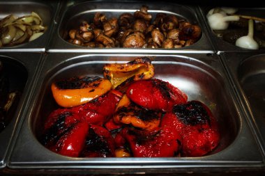 Izgara sebze. Izgarada pişmiş çeşitli sıcak hazır yemek çeşitleri. Bir sokak fuarında yiyecek satmak. Gidecek sokak yemeği. Fast food. Vejetaryen menüsü.