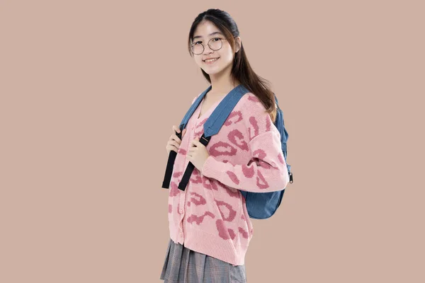 快乐的亚洲裔少女带着褐色背景的背包 高中教育的概念 — 图库照片