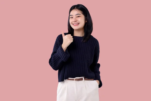 幸せな若いアジアの女性感じ幸せとジェスチャー親指アップピンクの背景に隔離 — ストック写真
