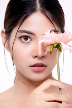 Güzel makyajlı Asyalı kadın, beyaz arka planda izole edilmiş taze ve taze derili çiçek tutuyor. Kozmetik, güzellik ve güzellik, sağlık, estetik cerrahi.