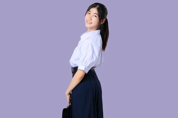 Portret Szczęśliwej Młodej Azjatyckiej Studentki Szkolnym Mundurku Odizolowanej Fioletowym Tle Obrazek Stockowy